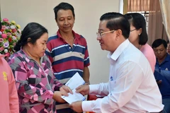 Chủ tịch Ủy ban Nhân dân thành phố Cần Thơ Trần Việt Trường (bên phải) trao tặng quà Tết hỗ trợ cho người dân khó khăn. (Ảnh: Trung Kiên/TTXVN) 