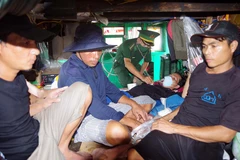 Tiếp nhận 5 ngư dân bị nạn trên biển vào bờ an toàn. (Ảnh: TTXVN phát) 