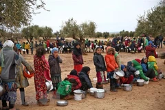 Trẻ em xếp hàng nhận lương thực cứu trợ tại tỉnh Aleppo, Syria. (Ảnh: AFP/TTXVN) 