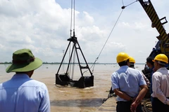 Thực hiện nghi thức khai thác những gàu cát đầu tiên tại mỏ cát trên sông Tiền (thuộc xã An Nhơn, huyện Châu Thành). (Ảnh: Nhựt An/TTXVN)