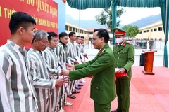 Thượng tá Nguyễn Văn Hải, Phó Giám thị trại giam Thanh Cẩm trao quyết định tha tù cho các phạm nhân nhân dịp Tết Nguyên đán 2023. (Ảnh: Phạm Kiên/TTXVN)