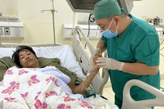 Bác sỹ Bệnh viện Bà Rịa-Vũng Tàu thăm khám cho bệnh nhân sau hậu phẫu. (Ảnh: Hoàng Nhị/TTXVN)