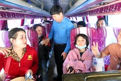 Ông Phạm Chí Tâm, Phó Chủ tịch Liên đoàn Lao động Thành phố Hồ Chí Minh lên tận ôtô tiễn công nhân về quê đón Tết. (Ảnh: Thanh Vũ/TTXVN)