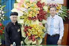 Phó Bí thư Thường trực Tỉnh ủy, Chủ tịch Hội đồng Nhân dân tỉnh An Giang Lê Văn Nưng (phải) tặng hoa chúc mứng Ban Trị sự Trung ương Giáo hội Phật giáo Hòa Hảo nhân kỷ niệm 84 năm Ngày Đức Huỳnh Giáo chủ khai sáng đạo Phật giáo Hòa Hảo. (Ảnh: Công Mạo/TTX