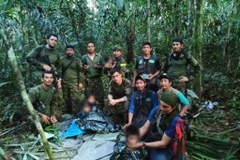 Đội cứu hộ chụp ảnh cùng các em nhỏ sau khi các em được tìm thấy tại rừng nhiệt đới Amazon, ngày 9/6/2023. (Nguồn: AFP/TTXVN)