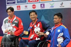 Nguyễn Hoàng Nhã (giữa) giành huy chương Vàng nội dung bơi ngửa nam 100m hạng thương tật S7, phá kỷ lục. (Ảnh: Hoàng Minh/TTXVN) 
