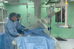 Các bác sỹ liên chuyên khoa tiến hành can thiệp cứu sống bệnh nhân. (Ảnh: TTXVN phát)