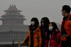 Khách du lịch đeo khẩu trang tránh bụi tại Bắc Kinh. (Nguồn: THX/TTXVN)