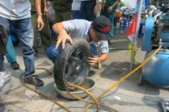 Vá lốp xe bị cán đinh. (Ảnh: Hải Âu/TTXVN)