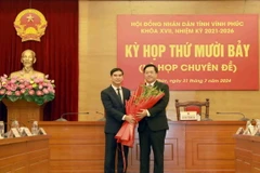 Bí thư Tỉnh ủy Vĩnh Phúc Dương Văn An (trái) chúc mừng Chủ tịch Ủy ban Nhân dân tỉnh Vĩnh Phúc Trần Duy Đông. (Ảnh: Hoàng Hùng/TTXVN)