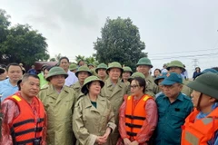 Bà Bùi Thị Minh Hoài, Bí thư Thành ủy Hà Nội (đứng giữa), trao đổi, động viên lực lượng xung kích phòng chống lũ tại huyện Quốc Oai. (Ảnh: Nguyễn Văn Cảnh/TTXVN)