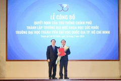 Phó Giáo sư, Tiến sỹ Huỳnh Thành Đạt, Bộ trưởng Bộ Khoa học và Công nghệ trao quyết định thành lập Trường Đại học Khoa học Sức khỏe cho Phó Giáo sư, Tiến sỹ Vũ Hải Quân. (Nguồn: Đại học Quốc gia Thành phố Hồ Chí Minh)