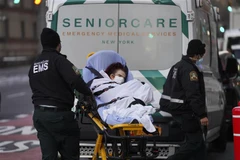 Nhân viên y tế chuyển bệnh nhân COVID-19 tới bệnh viện ở New York, Mỹ. (Ảnh: THX/TTXVN)