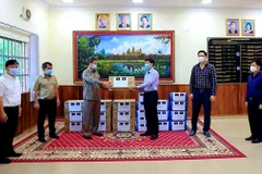 Tổng Lãnh sự Vũ Ngọc Lý (phải) trao số vật tư phòng chống dịch COVID-19 cho Tỉnh trưởng Kouch Chamroeun. (Ảnh: Trần Long/Vietnam+)