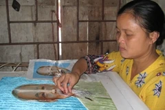 Chị Hoàng Thị Khương đang thêu bức chân dung Bác Hồ. (Ảnh: Ngọc Cương/Vietnam+)