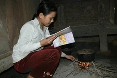 Em Vũ Thị Lệ Chi vừa học vừa giúp mẹ việc nhà. (Ảnh: Ngọc Cương/ Vietnam+)