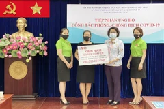 Bà Tô Thị Bích Châu, Chủ tịch Ủy ban MTTQ Việt Nam Thành phố Hồ Chí Minh (giữa) tiếp nhận kinh phí ủng hộ mua vaccine phòng, chống COVID-19 từ đại diện các doanh nghiệp, tổ chức. (Ảnh: Xuân Khu/TTXVN)