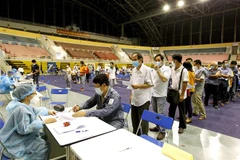Người lao động xếp hàng chờ thực hiện các thủ tục khai báo y tế trước khi tiêm vaccine phòng COVID-19 tại Nhà thi đấu Phú Thọ. (Ảnh: Thanh Vũ/TTXVN)
