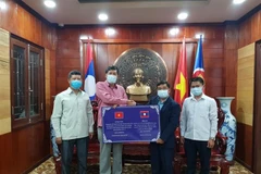 Đại diện Chính quyền tỉnh Bokeo trao tặng tiền hỗ trợ 3 tỉnh của Việt Nam phòng, chống dịch COVID-19. (Ảnh: TTXVN phát)