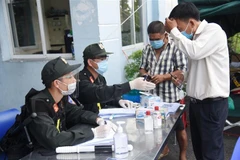 Lực lượng chức năng tại chốt kiểm soát trên quốc lộ 51, đoạn giao với cao tốc Thành phố Hồ Chí Minh - Long Thành - Dầu Giây hướng dẫn người dân đi từ Thành phố Hồ Chí Minh về Đồng Nai khai báo y tế. (Ảnh: Lê Xuân/TTXVN)