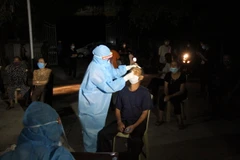 Lực lượng y bác sỹ xuyên đêm lấy mẫu xét nghiệm đối với các trường hợp là F1 của bệnh nhân số 11634 ở huyện Diễn Châu, Nghệ An. (Ảnh: Văn Tý/TTXVN)