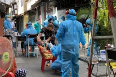 Tiến hành lấy mẫu xét nghiệm virus COVID-19 cho người dân trong khu vực bị phong tỏa tại TP.HCM. (Ảnh: Hồng Giang/TTXVN)