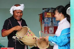 Già Ya Hiêng giới thiệu nghề đan lát truyền thống của người Churu cho du khách. (Nguồn: Báo ảnh Việt Nam/Vietnam+)