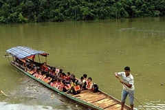 Các thầy Trường Phổ thông dân tộc bán trú Tiểu học số 1 xã Ta Gia đưa học sinh vượt sông Nậm Mu về trường. (Ảnh: Việt Hoàng/TTXVN)