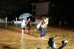 Lực lượng công an thành phố Yên Bái giúp người dân phường Hồng Hà di chuyển ra khỏi khu vực ngập úng trong đêm ngày 8/9. (Ảnh: TTXVN phát)