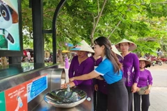 Du khách lấy nước miễn phí tại trạm nhà chờ và máy cấp nước. (Ảnh: Tường Vi/TTXVN)