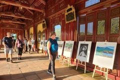 Du khách quốc tế tham quan triển lãm ảnh. (Ảnh: Mai Trang/TTXVN)