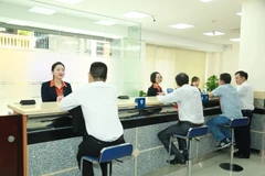 Hoạt động giao dịch tại Sacombank. (Ảnh: PV/Vietnam+)