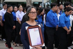 Bà Nguyễn Thị Tuyết (Bình Dương) mang theo bài thơ mình sáng tác về Tổng Bí thư Nguyễn Phú Trọng chờ vào viếng Tổng Bí thư tại Hội trường Thống Nhất, Thành phố Hồ Chí Minh sáng 26/7/2024. (Ảnh: Thu Hương/ TTXVN)