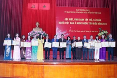 Trao tặng Bằng khen của Ủy ban Trung ương Mặt trận Tổ quốc Việt Nam cho các cá nhân kiều bào tiêu biểu. (Ảnh: Xuân Khu/TTXVN)