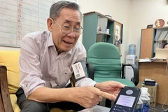 Giáo sư, Tiến sỹ Võ Văn Tới giới thiệu về thiết bị đo huyết áp và nhịp tim viễn thông - một sản phẩm đang trong quá trình chuyển giao công nghệ. (Ảnh: Thu Hoài/TTXVN