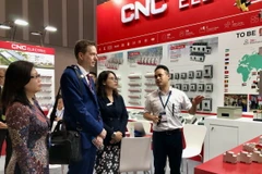 Doanh nghiệp giới thiệu sản phẩm đến khách tham quan chuỗi triển lãm. (Ảnh: Mỹ Phương/TTXVN)