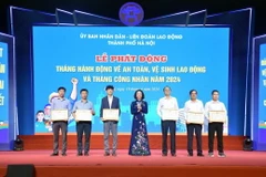 Phó Chủ tịch Ủy ban Nhân dân thành phố Hà Nội Vũ Thu Hà trao khen thưởng cho tập thể, cá nhân có thành tích trong công tác an toàn vệ sinh lao động. (Ảnh: TTXVN phát)