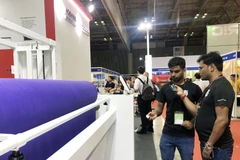 Khách tìm hiểu công nghệ tự động hóa tại triển lãm chuyên ngành dệt may ở Thành phố Hồ Chí Minh. (Ảnh: Hồng Nhung/ TTXVN)