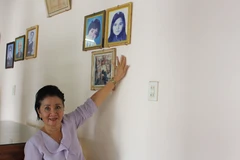 Bà Nguyễn Thị Ngọc Bích kể chuyện về sự kiện gia đình bà may 2 lá cờ giải phóng trước những năm 1975 và hình ảnh của chị gái-liệt sỹ Nguyễn Thị Ngọc Oanh. (Ảnh: Phan Sáu/ TTXVN)