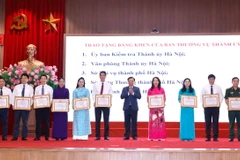Bí thư Thành ủy Hà Nội Đinh Tiến Dũng trao tặng Bằng khen của Ban Thường vụ Thành uỷ cho các đơn vị có thành tích xuất sắc. (Ảnh: Doãn Tấn/TTXVN)