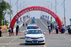 Những chiếc xe đầu tiên lưu thông qua cầu Châu Đốc bắc qua sông Hậu. (Ảnh: Thanh Sang/TTXVN)
