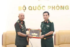 Đại tướng Phan Văn Giang trao quà lưu niệm tặng Đại tướng Tan Sri Datuk Seri Mohammad bin Ab Rahman. (Ảnh: Hồng Pha/TTXVN phát)