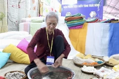 Nghệ nhân làng nghề lụa, đũi Nam Cao (Thái Bình) tái hiện hoạt động se sợi. (Ảnh: Xuân Anh/TTXVN)