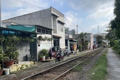 Người dân sống tại khu vực Km1697+150 (phường Trung Dũng, thành phố Biên Hoà, Đồng Nai) di chuyển sát đường sắt không có lan can bảo vệ tiềm ẩn nguy cơ mất an toàn giao thông. (Ảnh: Lê Xuân/TTXVN)