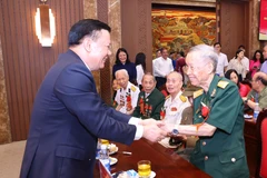 Bí thư Thành ủy Hà Nội Đinh Tiến Dũng với Đại tá La Văn Cầu, Anh hùng lực lượng vũ trang nhân dân Việt Nam tại buổi gặp mặt. (Ảnh: Văn Điệp /TTXVN)