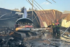 Lực lượng cảnh sát phòng cháy chữa cháy nỗ lực dập tắt đám cháy tại Công ty trách nhiệm hữu hạn sản xuất bao bì Hợp Nhất. (Ảnh: TTXVN phát)