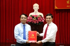 Đồng chí Nguyễn Hoài Anh (bên phải), Bí thư Tỉnh ủy Bình Thuận trao Quyết định cho đồng chí Đặng Hồng Sỹ. (Ảnh: Nguyễn Thanh/TTXVN)