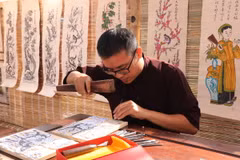 Trình diễn khắc tranh gỗ tại buổi tái hiện không gian Chợ tranh Đông Hồ. (Ảnh: Thanh Thương/TTXVN)