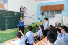 Một giờ học của học sinh khuyết tật khiếm thính khối 2-3, cô giáo hướng dẫn học sinh diễn đạt từ ngữ bằng ngôn ngữ ký hiệu. (Ảnh: Phan Sáu/TTXVN)