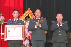 Thượng tướng Phùng Sĩ Tấn, Phó Tổng Tham mưu trưởng Quân đội Nhân dân Việt Nam trao Huân chương Bảo vệ Tổ quốc hạng Ba cho Trung tâm hành động bom mìn Quốc gia Việt Nam. (Ảnh: Trọng Đức/TTXVN)